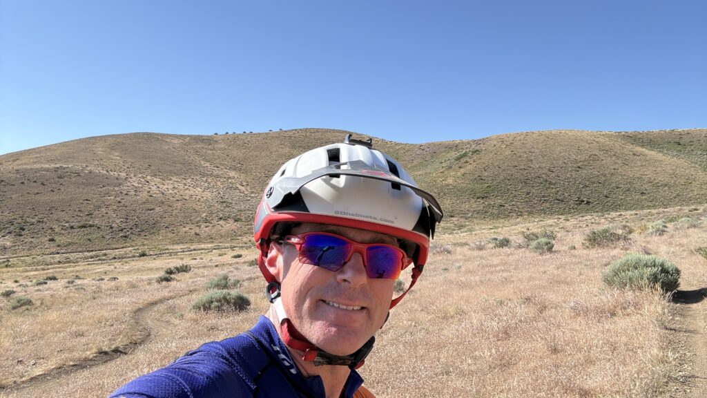 Cycling coach Richard Wharton wearing a helmet and sunglasses on a mountain bike trail on Peavine Mountain in Reno.